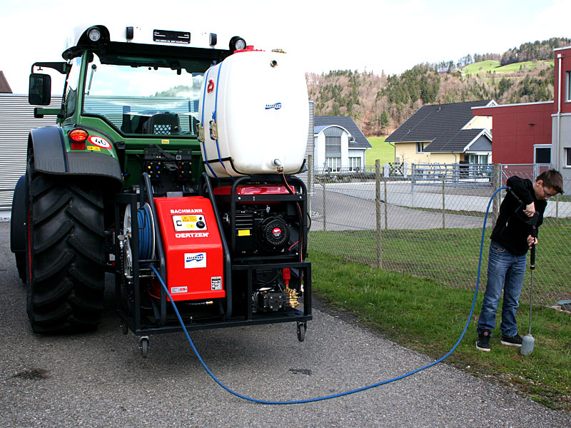 Heisswasseranlage am Traktor im Einsatz: Bediener behandelt den Strassenrand mit der Lanze
