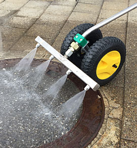 Unkrautdüse mit 22 cm Arbeitsbreite und Rollen bei der Flächenbehandlung auf einem befestigten Weg